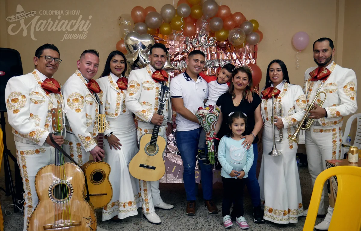 Mariachi Colombia Show posando con una familia y sus niños en una celebración con globos